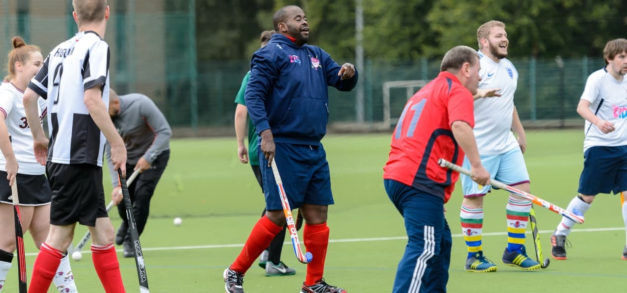 Field hockey players gathered on an artificial pitch